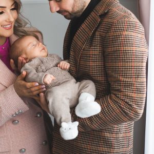 Mother and father holding their young baby boy in their hands.